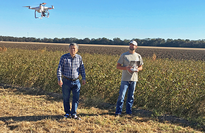 Scientists flying drone to search for weeds in a field
