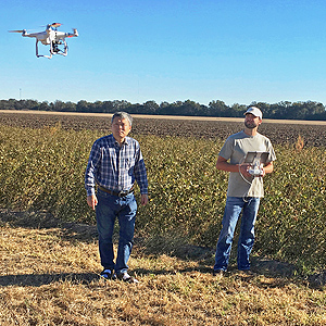 Scientists flying drone to search for weeds in a field