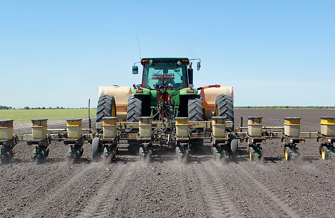 Tractor plants cotton and applies fungicide to field
