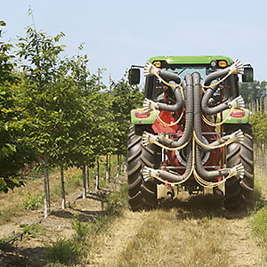 Tractor with new variable sprayer applying pesticides at a nursery.